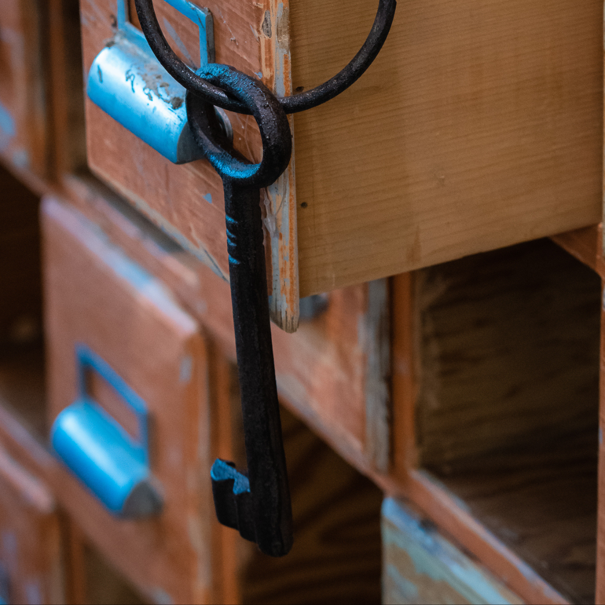vintage steel key hanging over corner of drawer